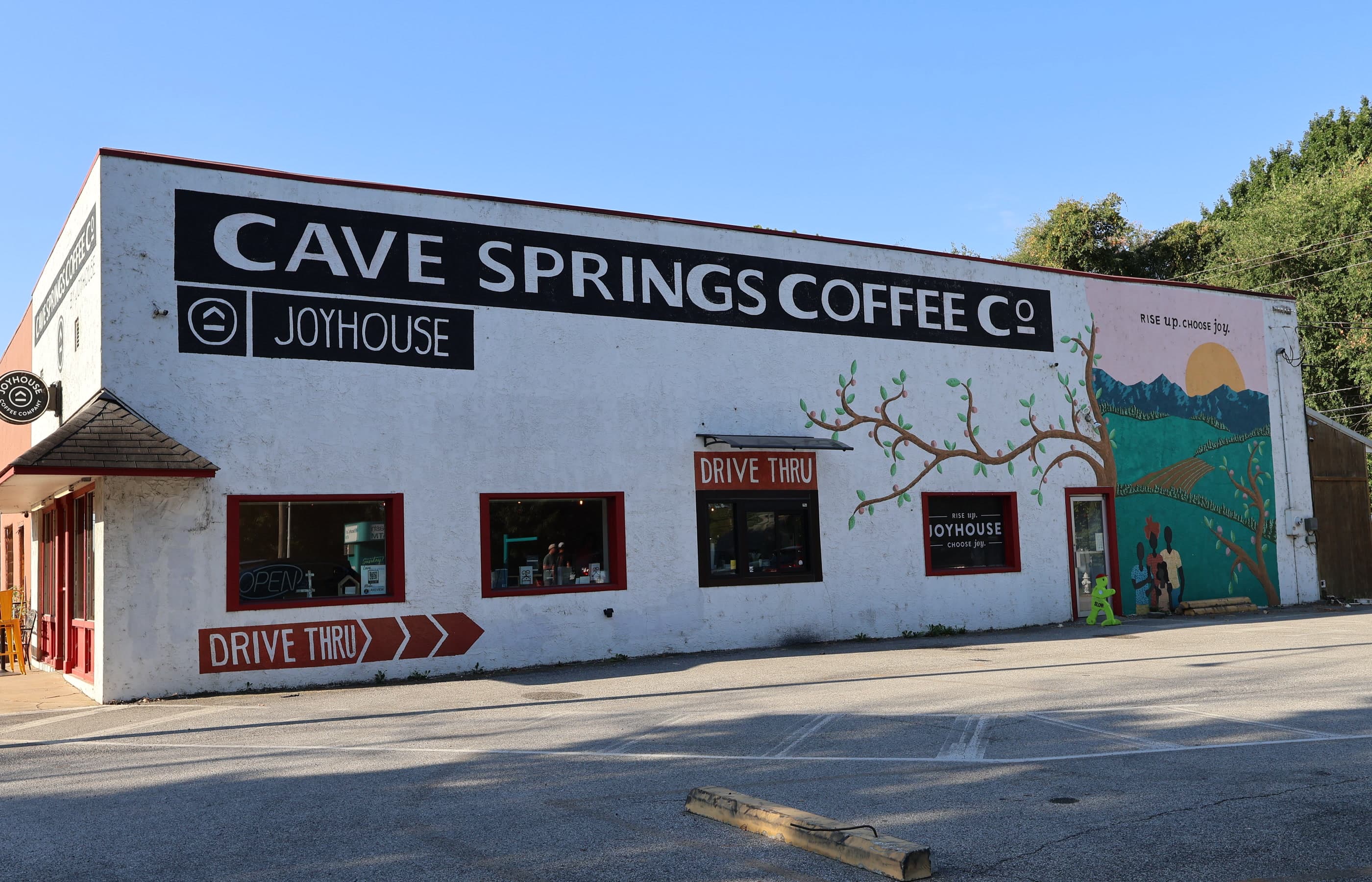 Joyhouse Coffee at 137 N Main Street in Cave Springs — the Cave Springs Coffee Co. signage, the drive-thru, and the hillside mural