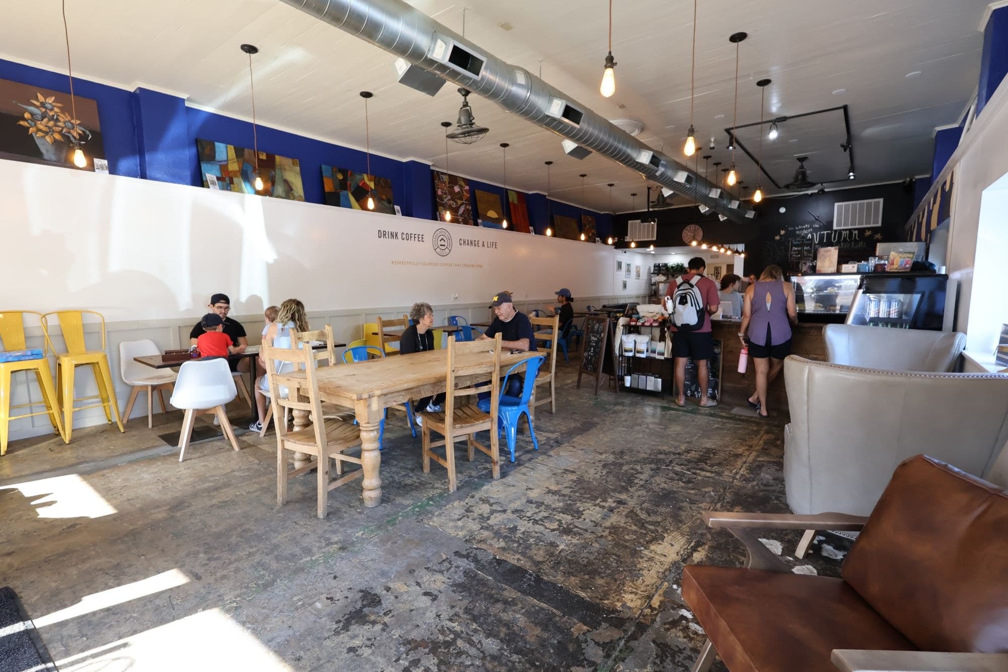 Inside the Joyhouse cafe in Cave Springs — customers at the communal table, counter at the far end